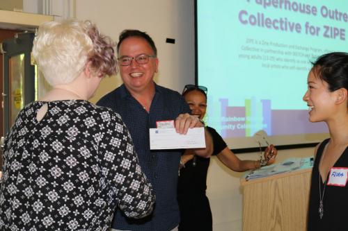 Rainbow Grants chairs Steven Solomon and Karen Arthurton present Paperhouse Outreach Collective their cheque.